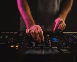 closeup-male-dj-working-lights-against-dark-background-studio